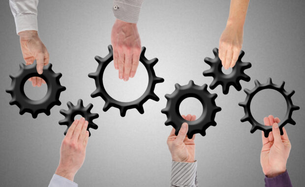 Hands holding gears together